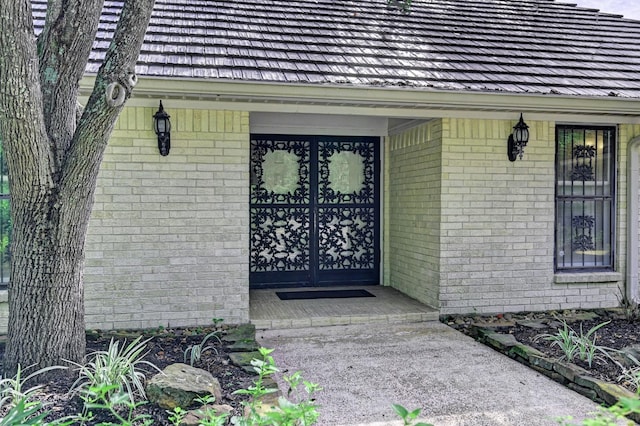 doorway to property featuring brick siding