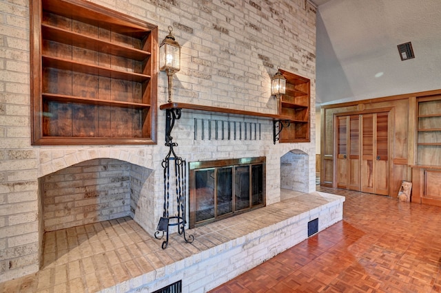 unfurnished living room featuring a fireplace, lofted ceiling, built in features, parquet floors, and a textured ceiling