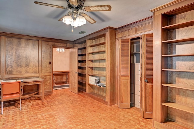 unfurnished office with visible vents, wood walls, ceiling fan, and ornamental molding