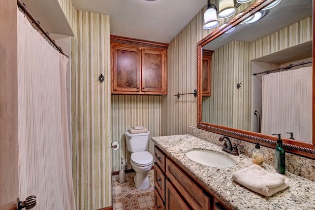 bathroom featuring vanity, toilet, and walk in shower