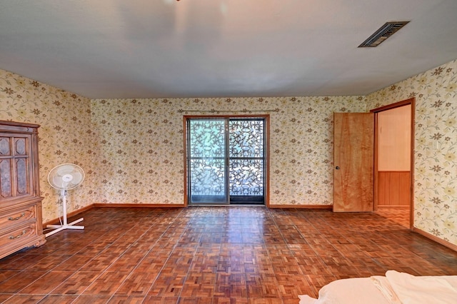 spare room featuring visible vents, baseboards, parquet flooring, and wallpapered walls