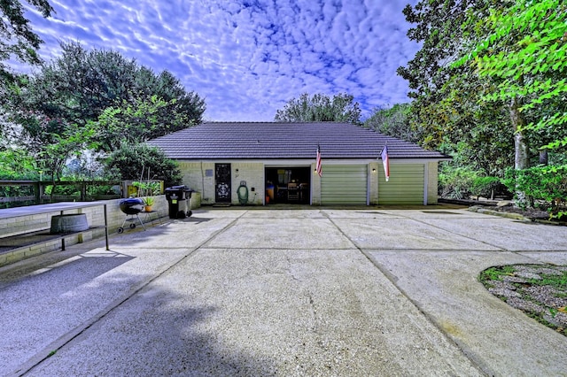 view of front of home featuring fence, an outdoor structure, and a tile roof