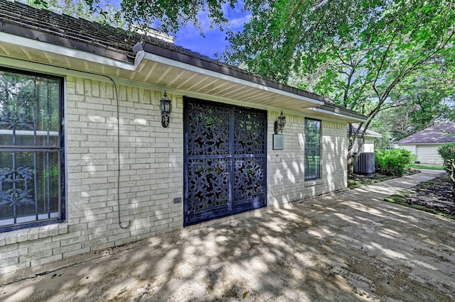 entrance to property with cooling unit and brick siding