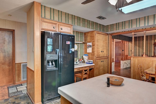 kitchen with visible vents, ceiling fan, black refrigerator with ice dispenser, and wallpapered walls