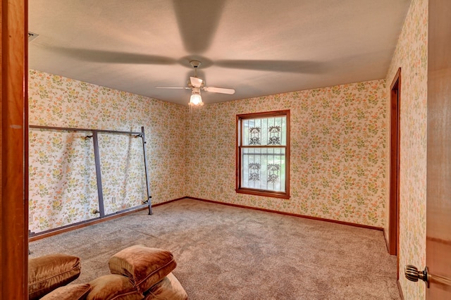 carpeted spare room with ceiling fan