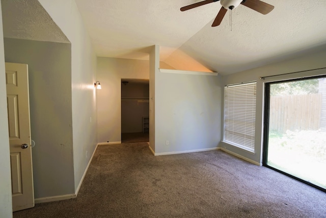 carpeted empty room featuring lofted ceiling, ceiling fan, and a textured ceiling