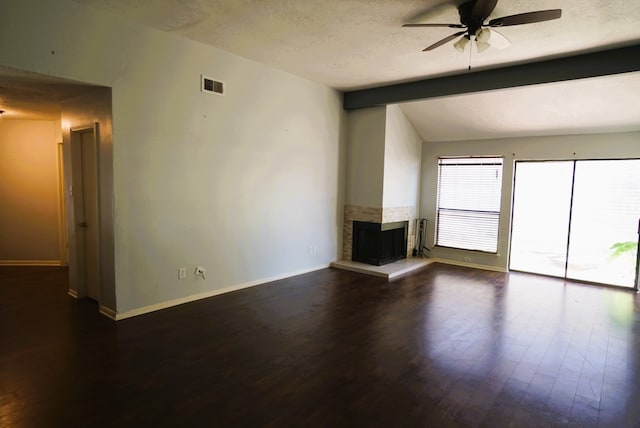 unfurnished living room featuring a textured ceiling, dark wood-type flooring, ceiling fan, and a multi sided fireplace