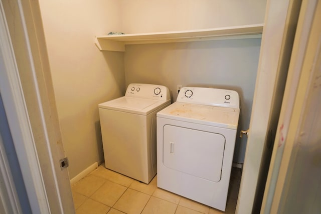 laundry area featuring light tile patterned floors and washing machine and clothes dryer