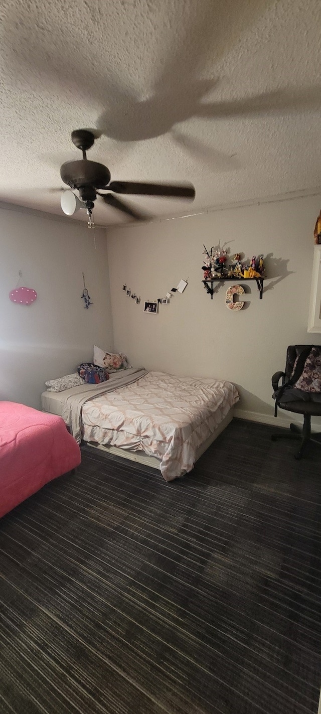 carpeted bedroom featuring a textured ceiling and ceiling fan