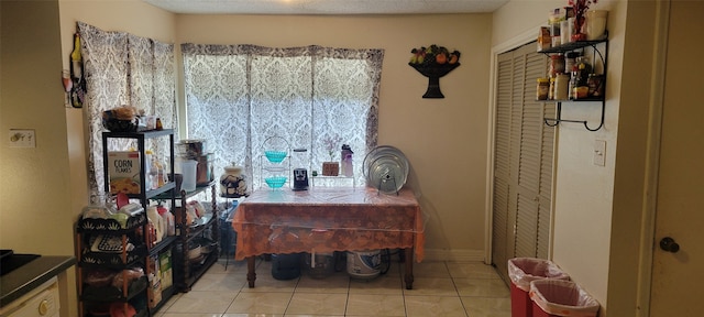 tiled dining room featuring a textured ceiling