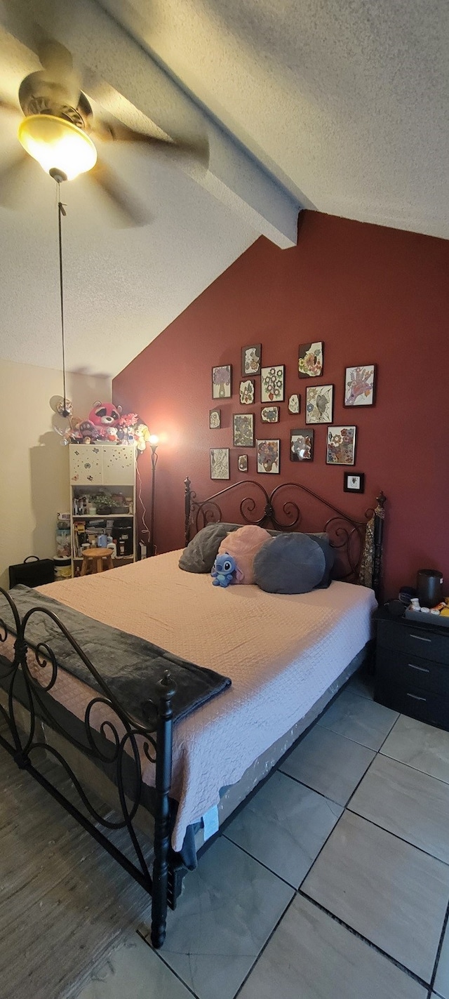 bedroom featuring ceiling fan, hardwood / wood-style flooring, lofted ceiling with beams, and a textured ceiling