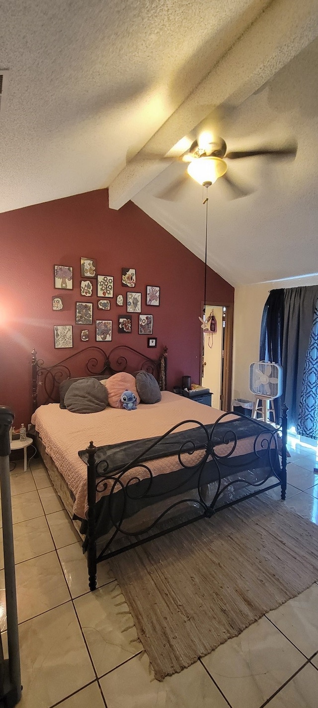 tiled bedroom with ceiling fan, lofted ceiling with beams, and a textured ceiling