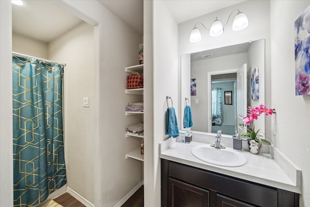 bathroom with a shower with shower curtain, hardwood / wood-style flooring, and vanity