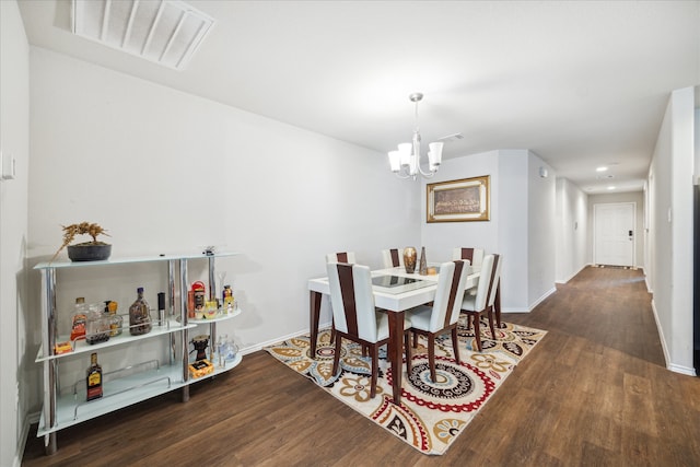 dining room with dark hardwood / wood-style floors and a chandelier