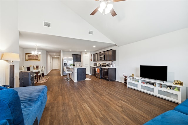 living room with ceiling fan with notable chandelier, dark wood-type flooring, and high vaulted ceiling