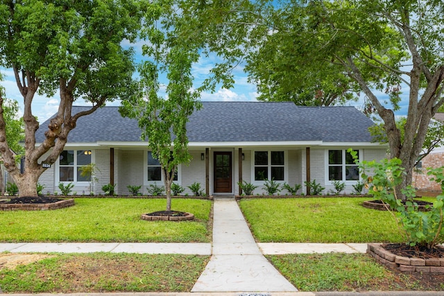 ranch-style house featuring covered porch and a front lawn