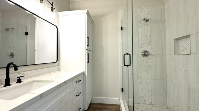 bathroom featuring a shower with door, vanity, and hardwood / wood-style flooring