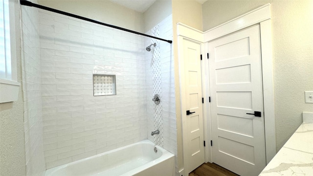 bathroom featuring vanity, wood-type flooring, and tiled shower / bath