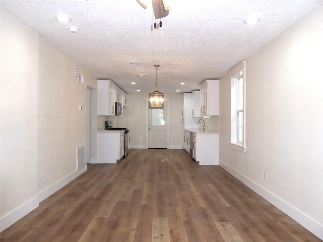 unfurnished living room featuring sink, dark hardwood / wood-style floors, and a textured ceiling