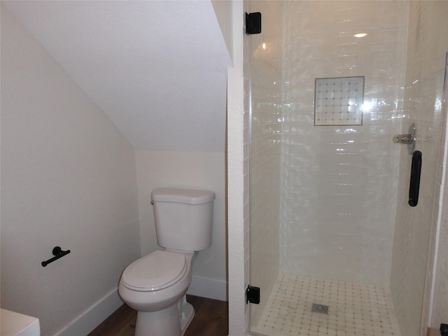 bathroom with walk in shower, hardwood / wood-style floors, lofted ceiling, and toilet