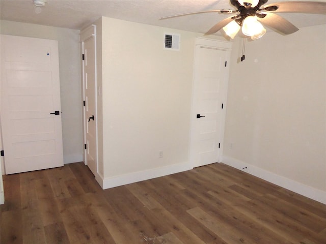 empty room with ceiling fan and dark hardwood / wood-style floors