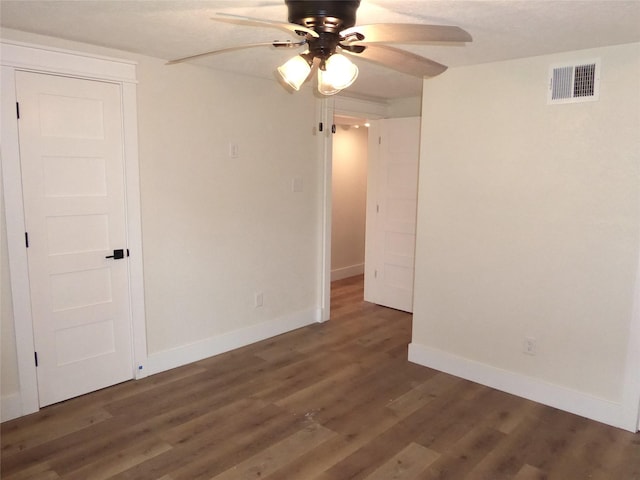 empty room with dark hardwood / wood-style flooring and ceiling fan