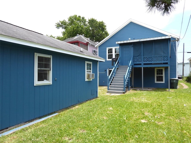 back of property featuring a sunroom and a yard