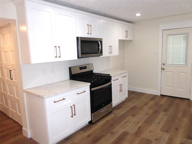 kitchen with white cabinetry, dark hardwood / wood-style flooring, stainless steel appliances, and light stone counters