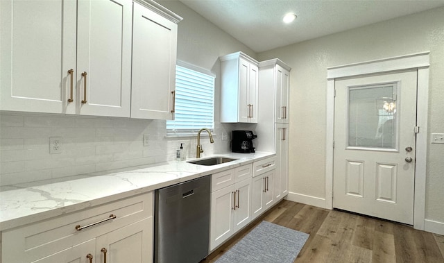 kitchen featuring dishwasher, white cabinets, tasteful backsplash, and sink