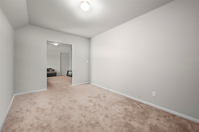 empty room with lofted ceiling and carpet floors