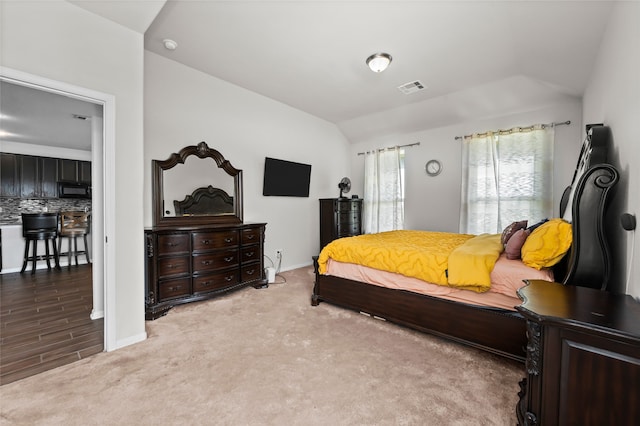 bedroom with lofted ceiling and wood-type flooring