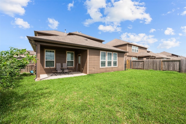 rear view of house featuring a yard and a patio area