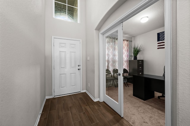 foyer entrance with french doors and dark wood-type flooring