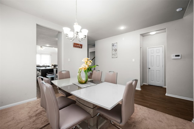 dining room with wood-type flooring, sink, and a notable chandelier