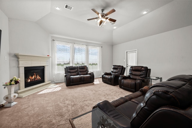 carpeted living room with lofted ceiling, ceiling fan, and a tiled fireplace