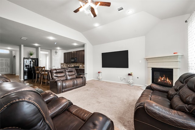 living room with ceiling fan, dark colored carpet, and vaulted ceiling