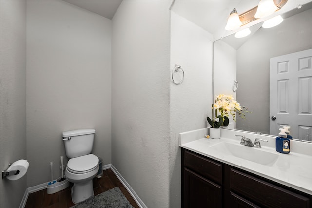 bathroom with vanity, toilet, and hardwood / wood-style flooring