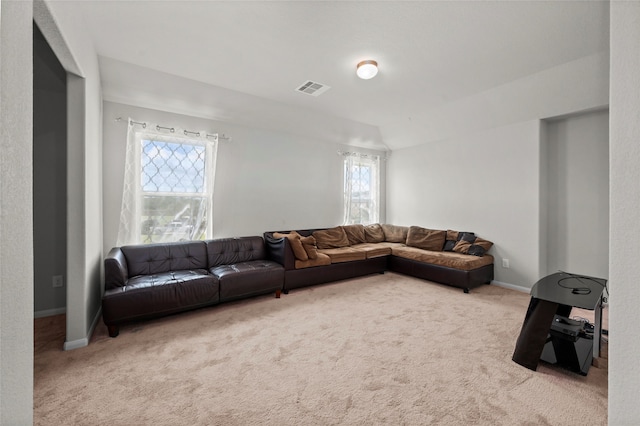 carpeted living room featuring plenty of natural light and vaulted ceiling