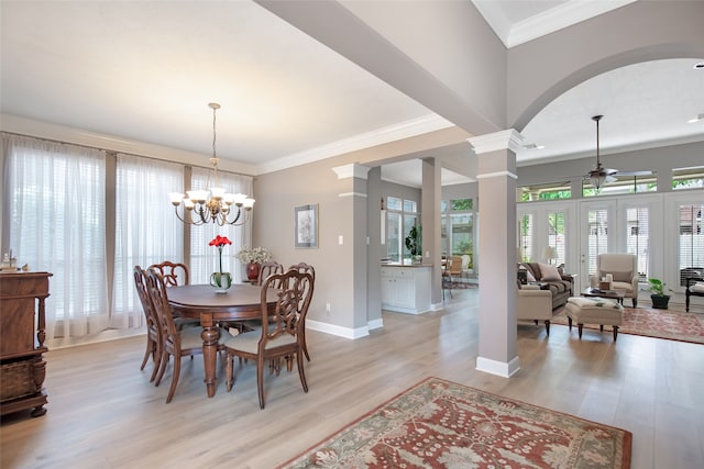 dining room featuring ceiling fan with notable chandelier, light wood-type flooring, crown molding, and decorative columns