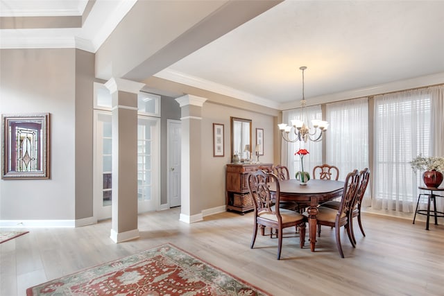 dining space featuring crown molding, light hardwood / wood-style flooring, a chandelier, and decorative columns