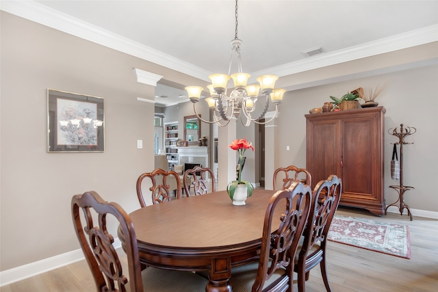 dining area featuring ornamental molding, a notable chandelier, and light wood-type flooring