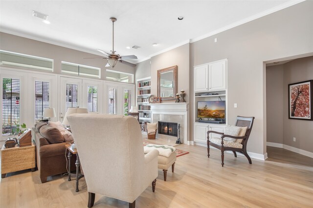 living room featuring light wood-type flooring, ceiling fan, and ornamental molding