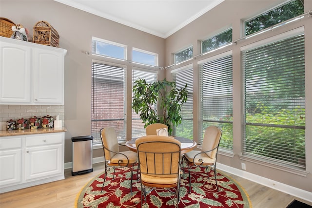 dining space featuring crown molding and light hardwood / wood-style flooring