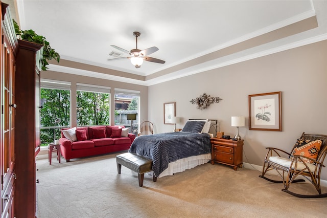 carpeted bedroom featuring crown molding, ceiling fan, and a raised ceiling