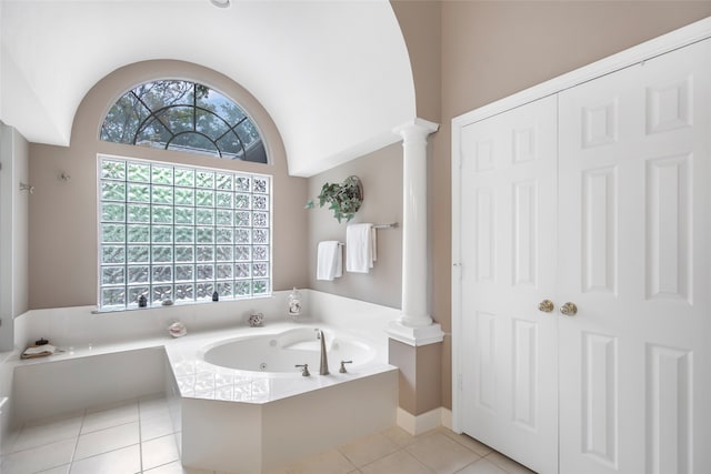 bathroom with a bath, decorative columns, vaulted ceiling, and tile patterned floors