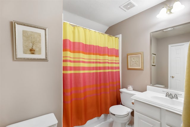 bathroom featuring vanity, toilet, and curtained shower