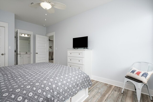 bedroom with light wood-type flooring, ceiling fan, and ensuite bathroom