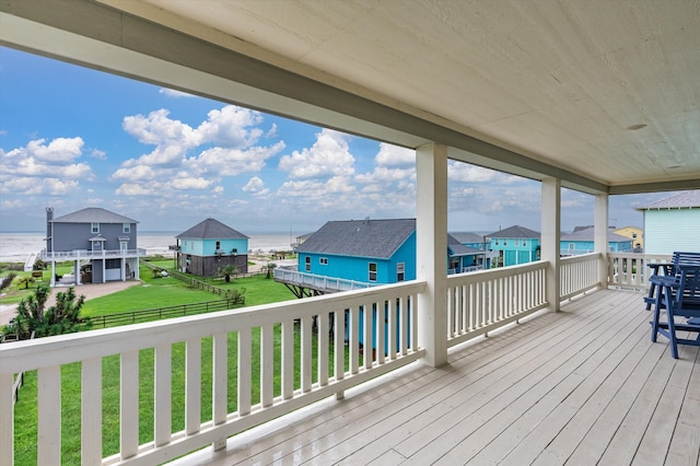 wooden terrace featuring a yard and a water view