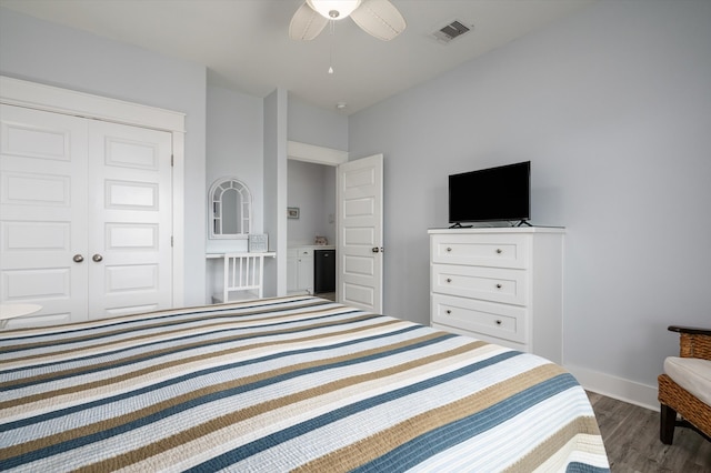 bedroom featuring a closet, dark hardwood / wood-style floors, and ceiling fan