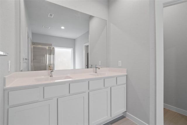 23415 Breckenridge Dale Ln, Spring, TX 77373 - bathroom featuring a stall shower, double vanity, wood finished floors, and baseboards